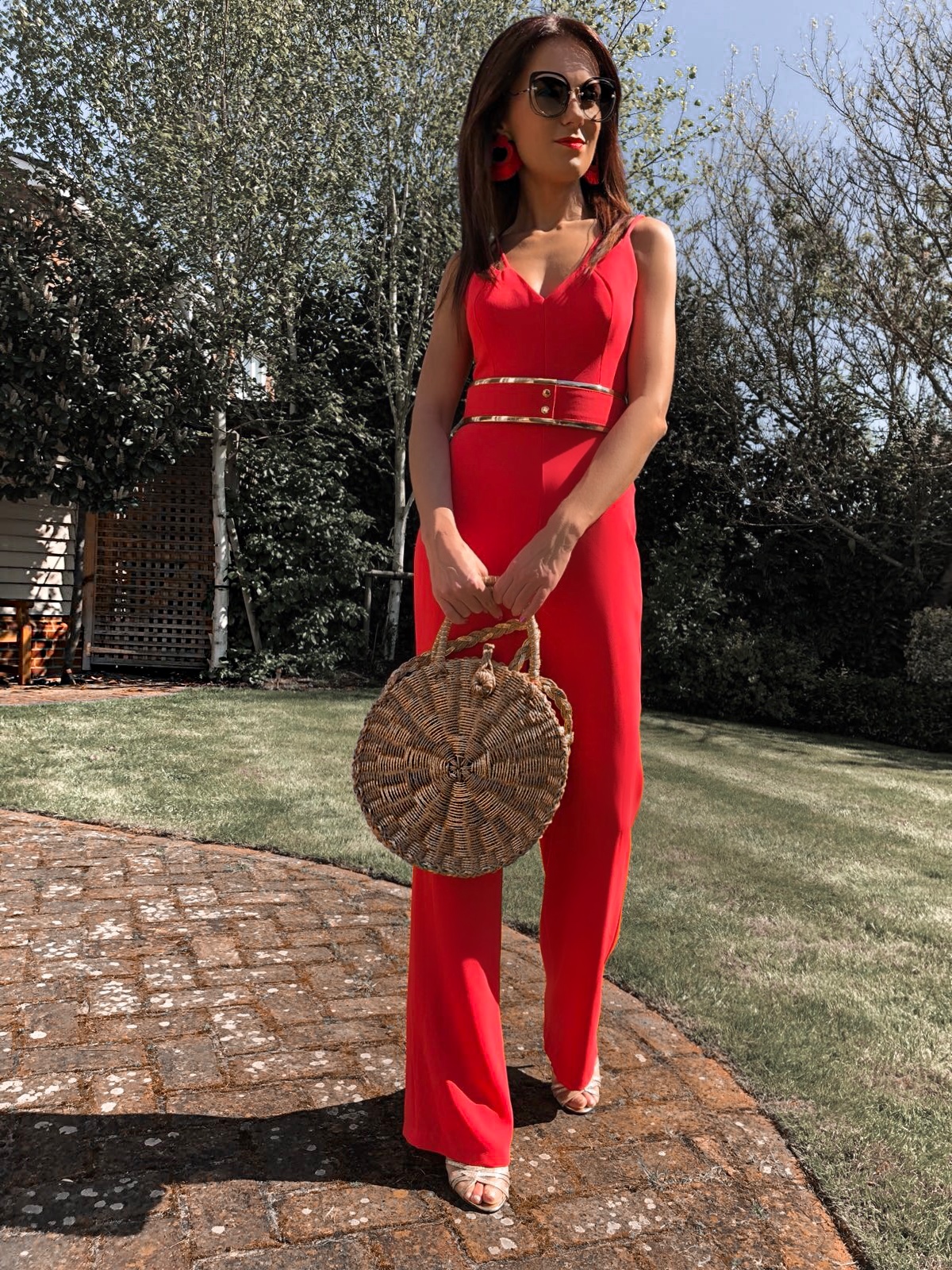 BROOKE - BRIGHT CORAL DOUBLE STRAP JUMPSUIT WITH GOLD WAISTBAND | South Beach Round Gold Woven Straw Cross Body Bag | Elegant Duchess Boutique Bohemian earrings