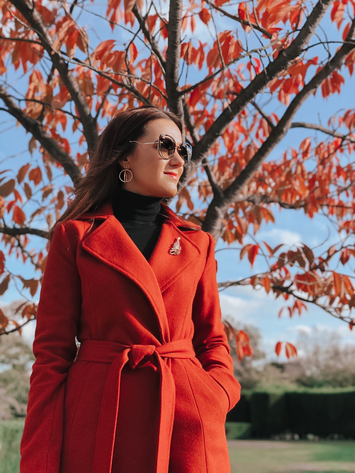 Lipsy Rust Wrap Coat | Elegant Duchess Boutique Brooch | Replay Jeans | Miu Miu sunglasses | Swarovski earrings