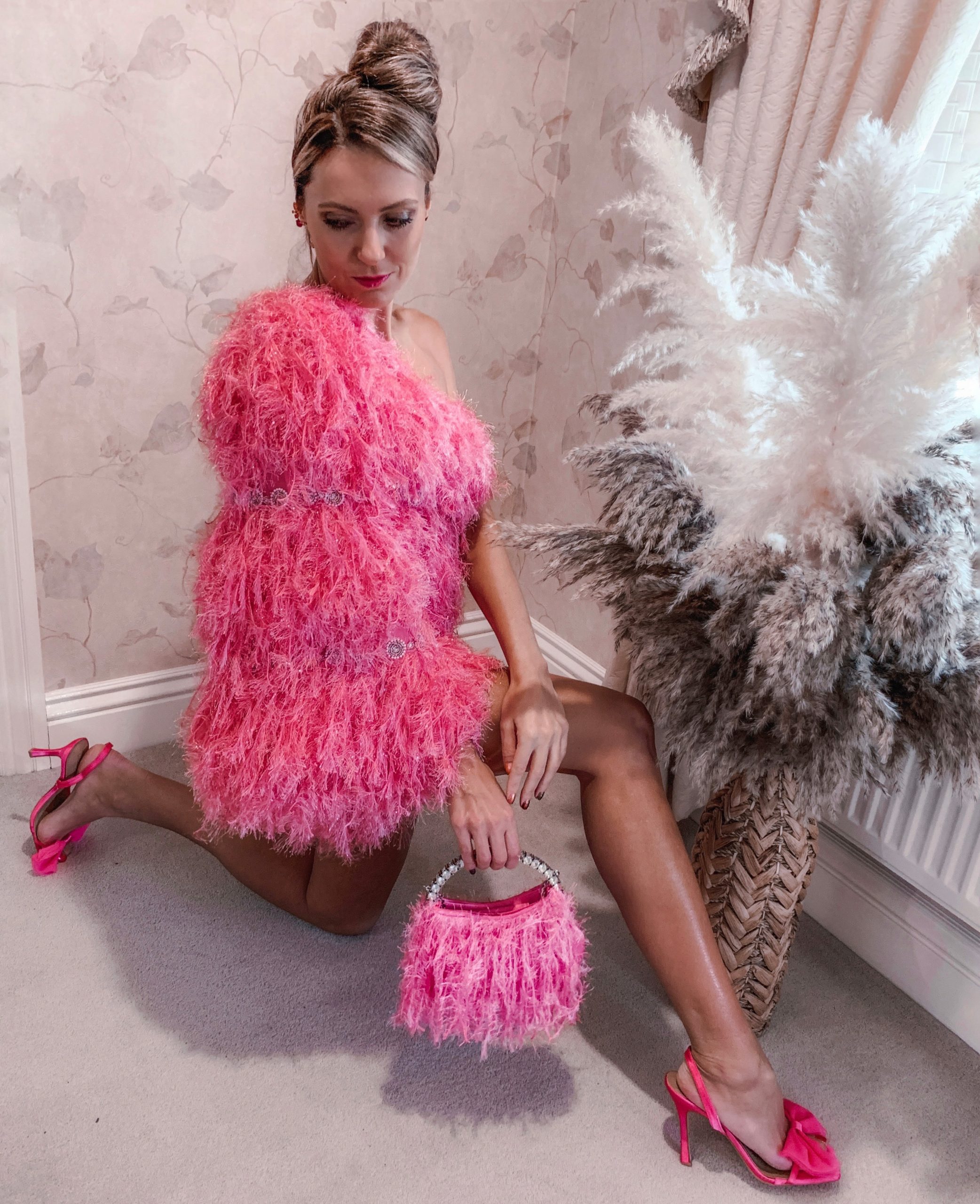 ASOS Luxe all over faux feather one sleeve mini dress in pink | Dune London Black Bonus Encrusted Heel Courts | ASOS clutch bag in feather with diamante top handle in pink | London Rebel bow sling back mid heel sandals in pink satin | Swarovski clip earrings