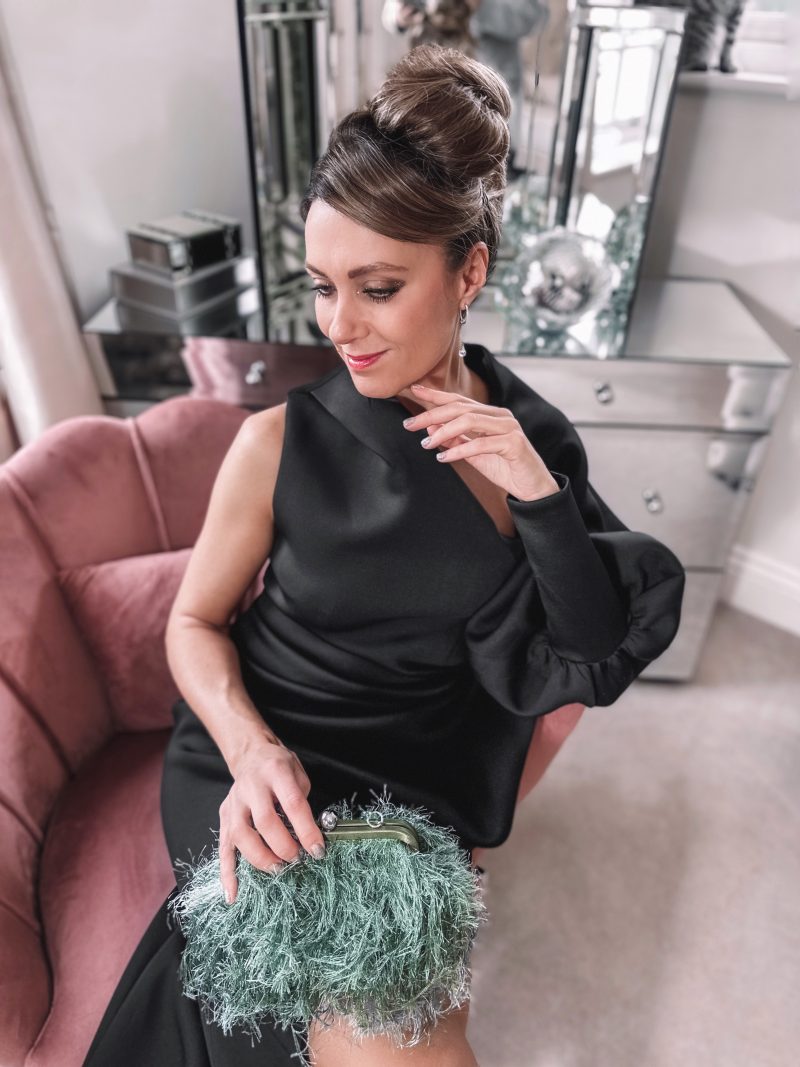 ASOS DESIGN Nettle faux feather embellished heeled mules in sage green, ASOS DESIGN one shoulder high split pleat pencil midi dress in black, ASOS DESIGN faux feather clutch with resin handle in sage
